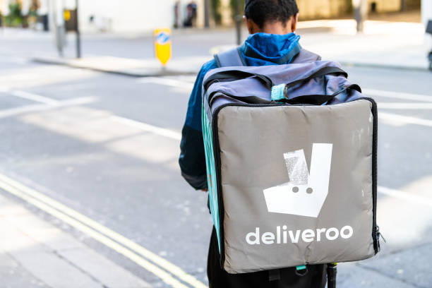 deliveroo zaino uomo con cartello blu nella zona di knightsbridge della città durante il giorno consegnando cibo da vicino su strada strada - bicycle london england cycling safety foto e immagini stock