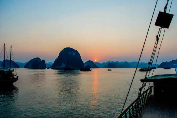 Photo of View of the orange setting sun on Ha Long Bay from the deck of a traditional boat