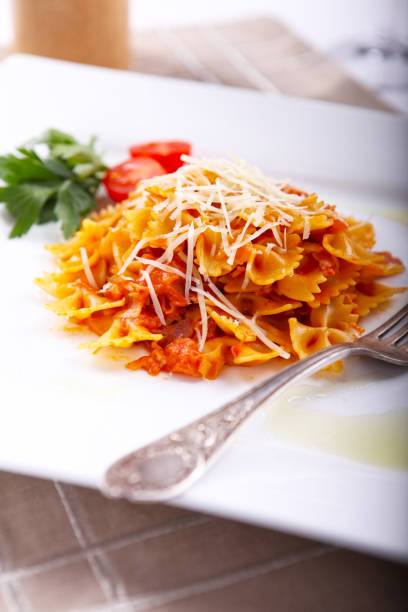 istock Farfalle pasta with sauce and cheese, served on a white plate. 1125786496