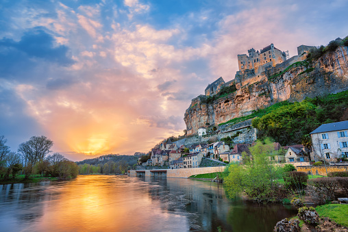 Beynac-et-Cazenac village with medieval Chateau Beynac on dramatic sunset, Dordogne, France. It is one of the most beautiful villages of France (les plus beaux villages de France)