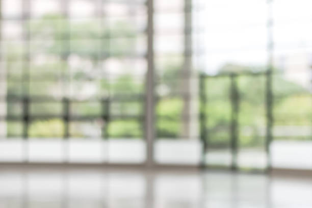 istock Blur background interior view looking out toward to empty office lobby and entrance doors and glass curtain wall 1125788822