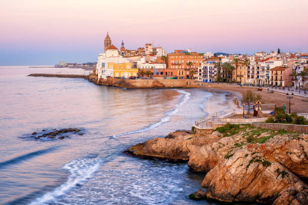 Sand beach and historical Old Town in mediterranean resort Sitges, Spain Sand beach and historical Old Town in mediterranean resort Sitges near Barcelona, Costa Dorada, Catalonia, Spain barcelona beach stock pictures, royalty-free photos & images