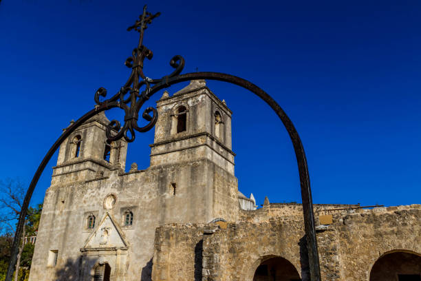 Interesting Angle with View of Bell Towers Through Well Arch of the Historic Old West Spanish Mission Concepcion, Established 1716, San Antonio, Texas.  Clear blue skies.