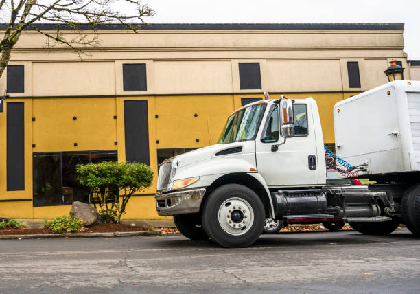 istock Middle class day cab rig semi truck with low semi trailer for local transporting and delivery driving on the city street 1125792122