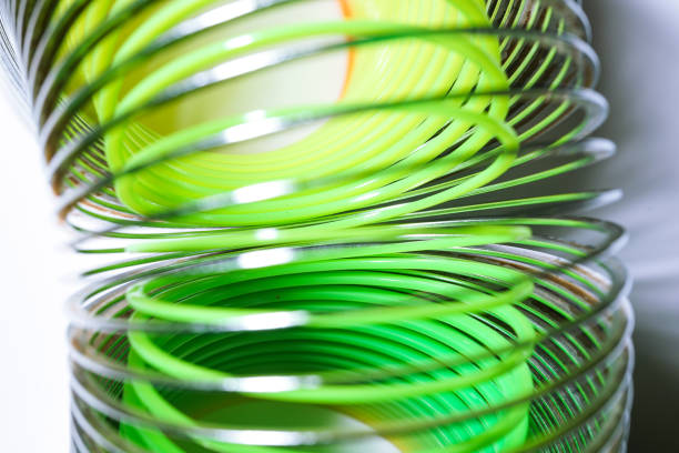 steel spring toy coil with plastic rainbow on white background