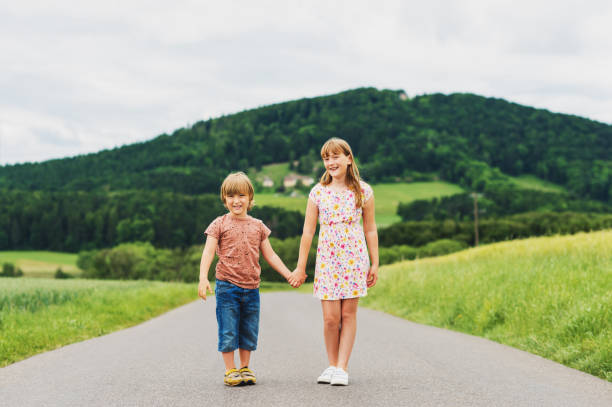istock Two adorable kids playing together in summer wheat field 1125795435