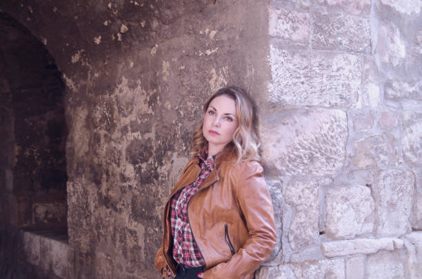 istock Pensive woman portrait leaning on stone wall,looking nostalgic 1125797593
