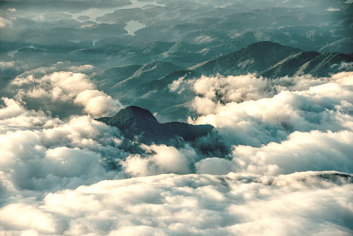 Hills and their tropical rain forests in São Paulo state, Brazil. Partially covered with clouds. Viewed from airplane.