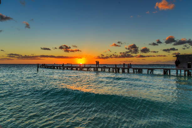 Sunset Women Island A wave comes in durring the end of sunset on a beach on Isla Mujeres, an island off of Cancun, Mexico. isla mujeres stock pictures, royalty-free photos & images