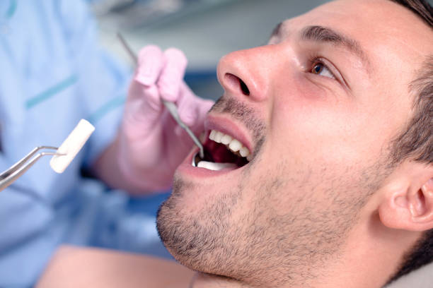 istock Dentist using dental equipment on men's teeth. 1125801091