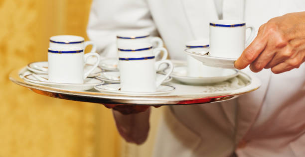 Waiter carrying tray with coffee cups on some festive event, party or wedding reception