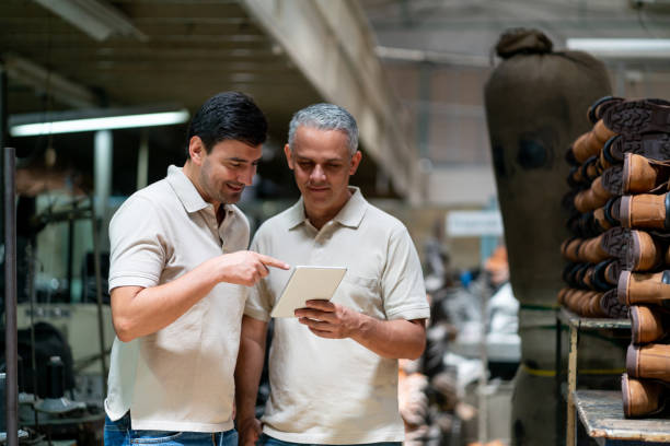 istock Supervisor and employee looking at a tablet while pointing at something smiling 1125804253