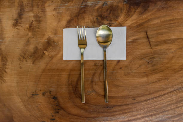 istock Golden 
fork and spoon setting on the wooden table background. 1125806189