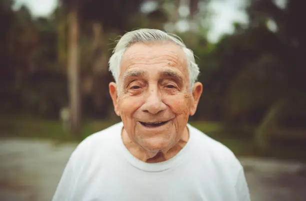 Italian man well into his 90’s in a candid portrait. He is a cheerful and active senior citizen with a unique and eccentric attitude. Outdoors and with a contagious smile