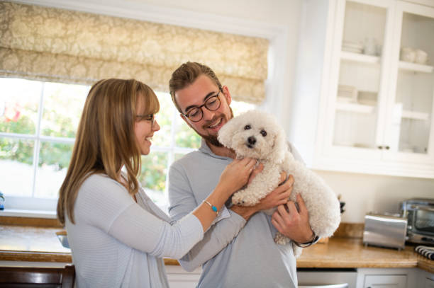 istock Young Couple Holding And Petting Their Dog 1125820807