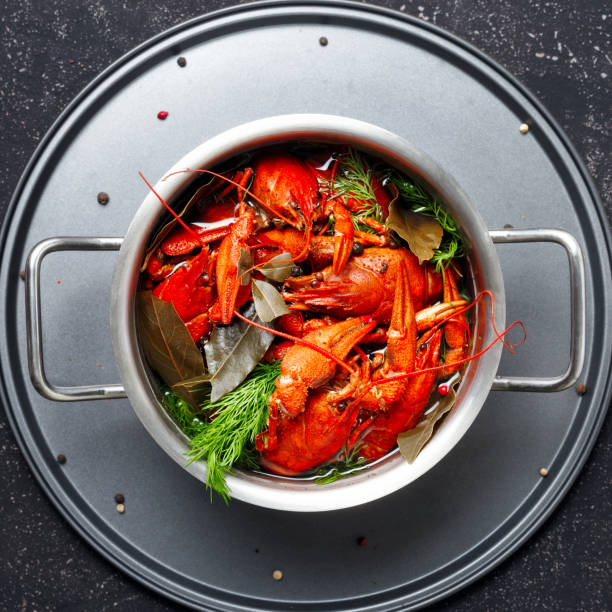 istock Boiled crawfish dill bay leaf saucepan black background top view 1125822904