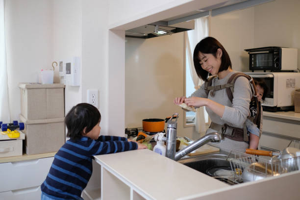 istock Mother cooking with baby on her back in kitchen 1125823106