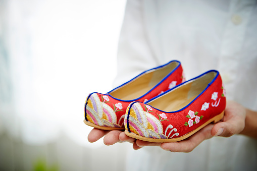 Korean woman holding traditional Korean shoes