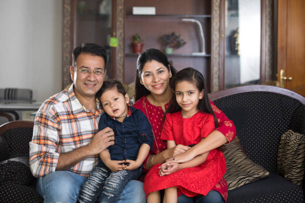 Happy Indian family sitting on sofa in the living room