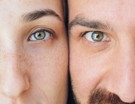 Close up shot. Eyes of brother and sister. Blue and green eyes. Looking through camera.