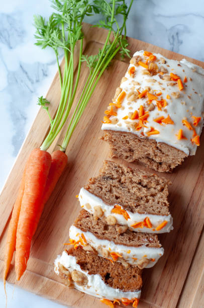 gâteau aux carottes avec carottes entières - baked cheese topping photos et images de collection