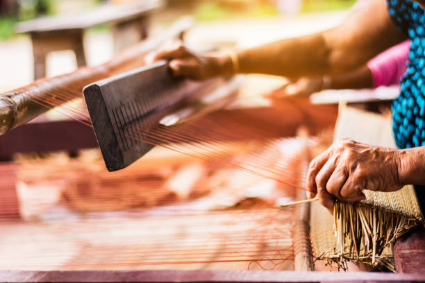 istock Asian woman weaving typical Thai straw mat from dry papyrus 1125826459