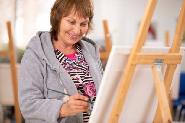 donna anziana al corso di pittura. - easel artists canvas paint paintings foto e immagini stock
