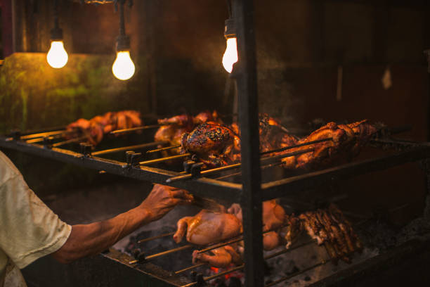 야외 거리 치킨 바베 큐 그릴은 팔과 손 브러시 침을 굽고 고기 음식을 굽는 주유 흡연 간단한 전기 조명에 살아있는 석탄에 구이 - chicken rotisserie barbecue grill roast chicken 뉴스 사진 이미지