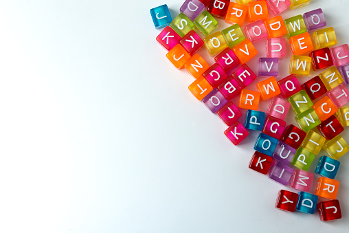 Many colorful decorative cubes with letters on a white background.