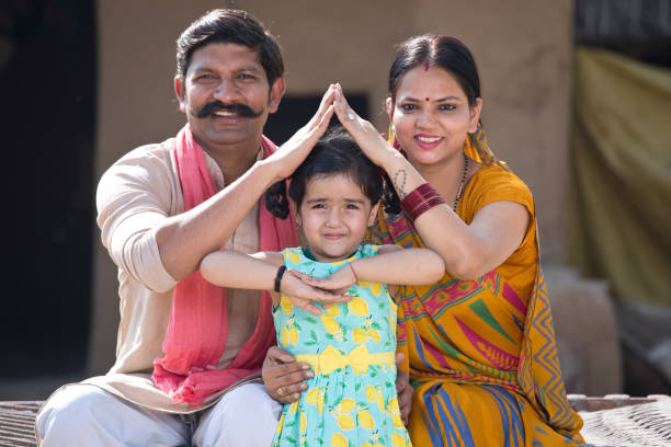 Rural Indian family forming house symbol with hands