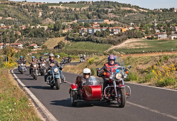 bikers riding Harley Davidson with sidecar bikers riding Harley Davidson with sidecar with a group of motorcyclists in motorcycle rally "Sangiovese tour" by Ravenna Chapter. Riolo Terme, RA, Italy - September 22, 2013 sidecar stock pictures, royalty-free photos & images