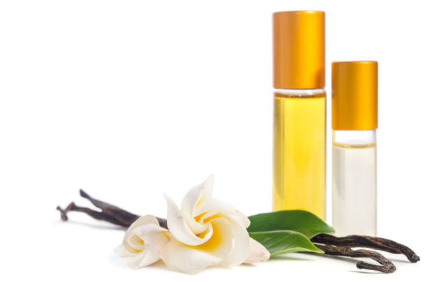 Hermosas flores, vainilla natural y botellas con aceites para la piel aislada sobre fondo blanco - foto de stock