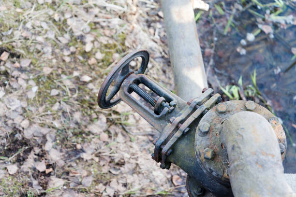 istock The valve on the pipe near the river. 1125835503