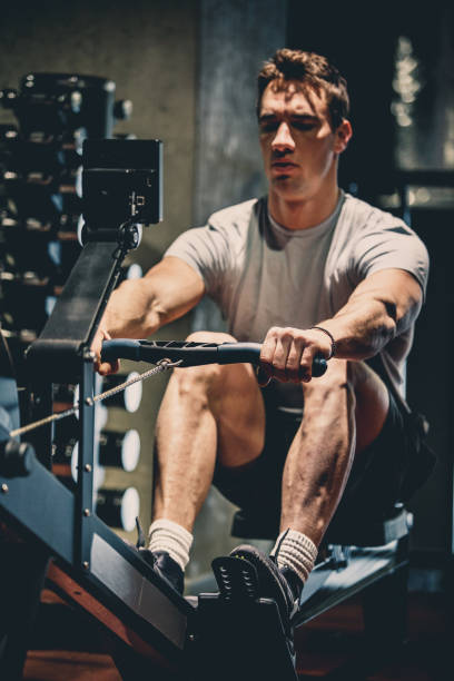 istock Man doing rowing machine exercises in the gym 1125837609