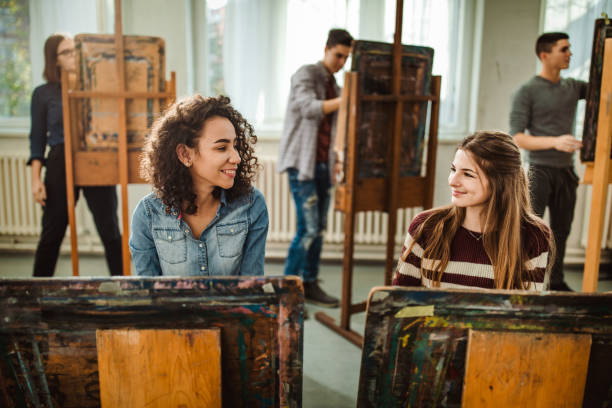istock Happy female students talking while making paintings at art studio. 1125838034