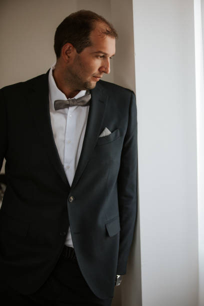 istock Handsome man in suit standing by the window 1125838103