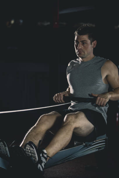 istock Man exercising on rowing machine in the gym 1125840252