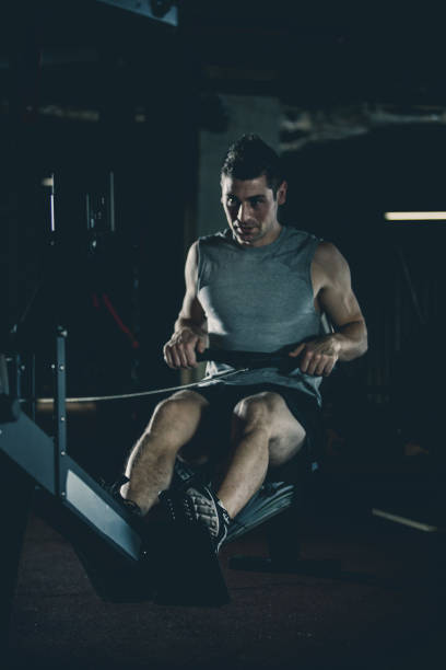 istock Man exercising on rowing machine at the gym 1125840256