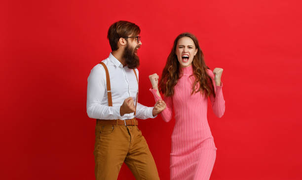 istock young happy couple won emotionally celebrating win on colored red background 1125840641