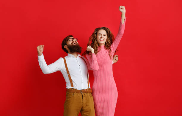 istock young happy couple won emotionally celebrating win on colored red background 1125840679