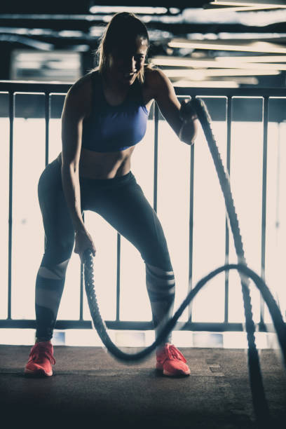 istock Smiling woman exercising with battle rope 1125840771