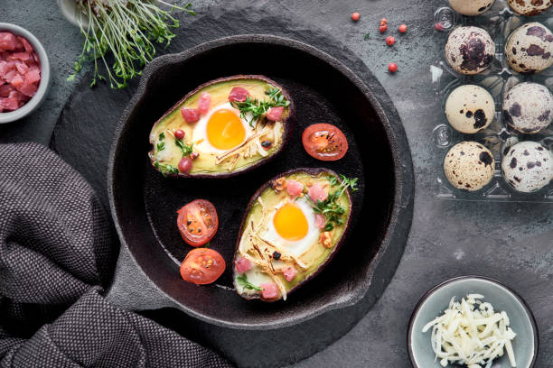 istock Keto diet dish: Avocado boats with ham cubes, quail eggs, cheese, ingredients around 1125843598