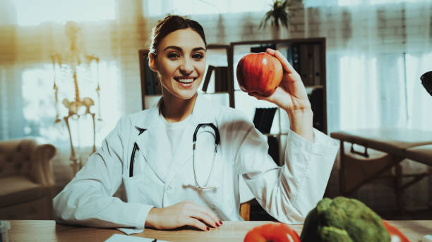 istock Female Doctor is Holding and Showing Red Apple 1125844459