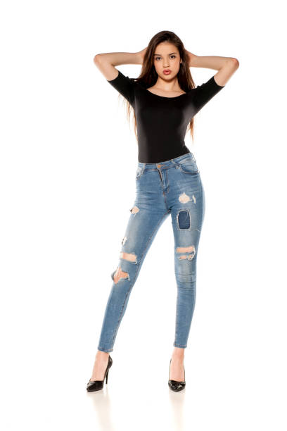 istock A young girl in a ripped jeans on white background 1125844533
