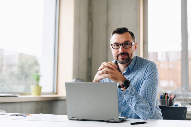 istock Thoughtful middle aged handsome businessman in shirt working on laptop computer in office 1125844584