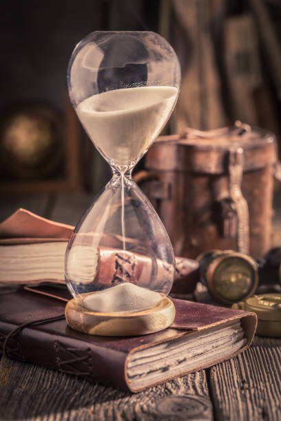 istock Aged hourglass and journal as a concept of journey diary 1125844639