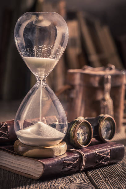istock Old hourglass and journal with binocular and compass 1125844734