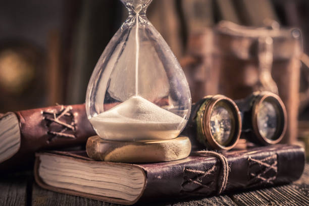 istock Aged hourglass and journal with binocular and compass 1125844781