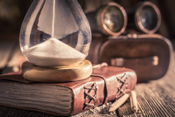 istock Vintage hourglass and journal as a concept of journey diary 1125844840