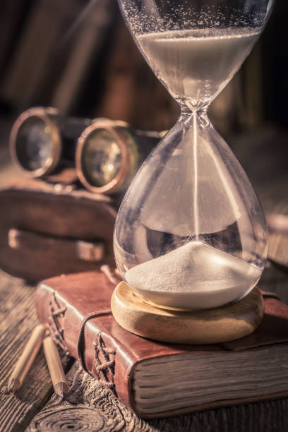 istock Closeup of hourglass and journal with compass and binocular 1125844857